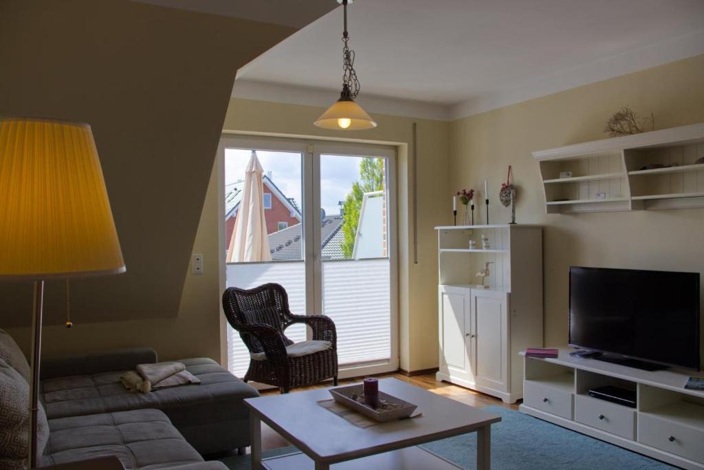 a living room with a couch and a table at Inselblume 07 - Ferienwohnung mit Hund an der Reiterkoppel in Neue Tiefe Fehmarn