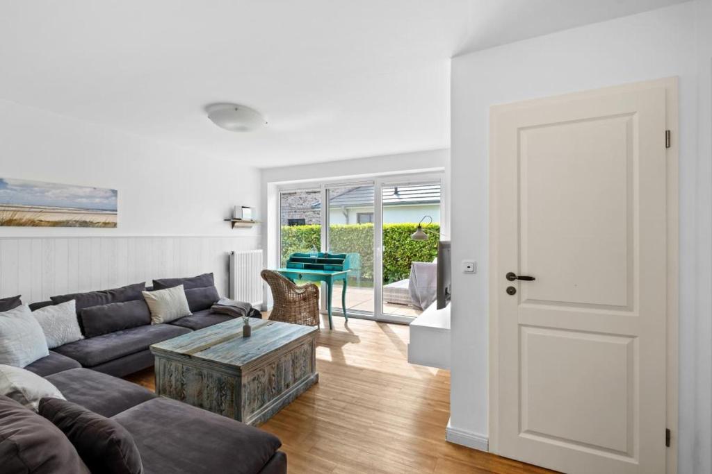 a living room with a couch and a table at Inselblume 35 - Moderne Ferienwohnung in Neue Tiefe in Neue Tiefe Fehmarn