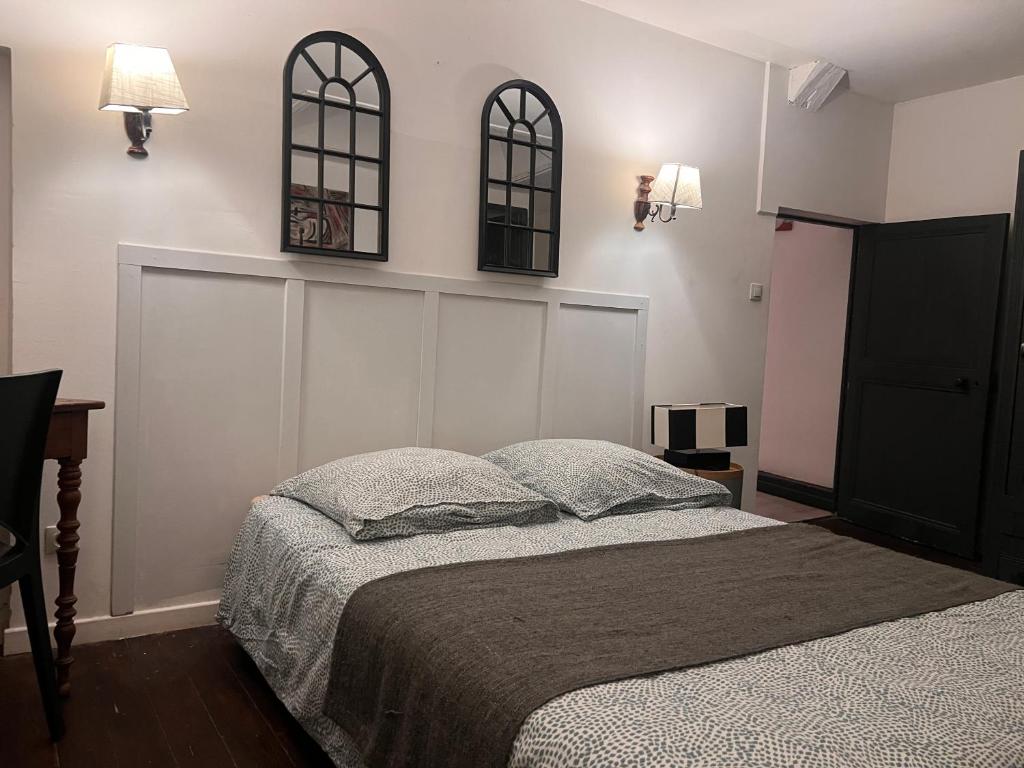een slaapkamer met een bed en twee spiegels aan de muur bij 4 - Les pins roses in Poitiers