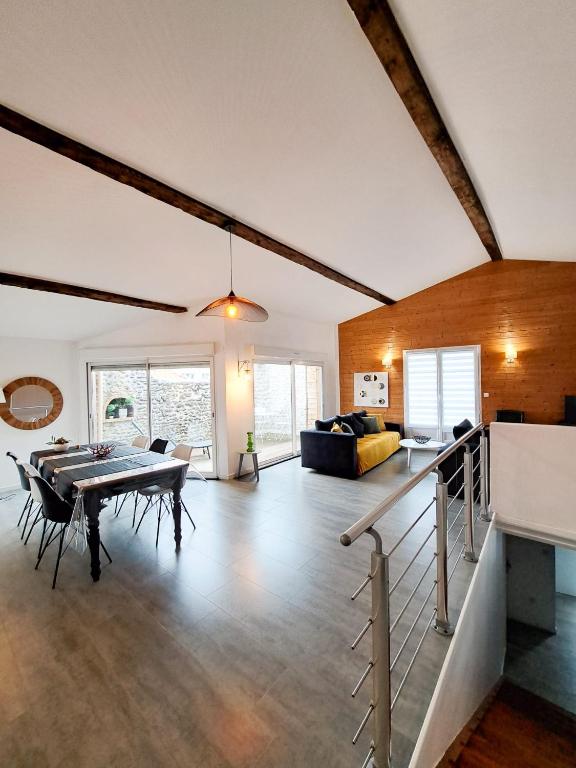 un salon avec une table et un canapé dans l'établissement Les Orangers - LOGEMENT INDÉPENDANT - 2 personnes - Patio - PROCHE DES THERMES DE SAUJON, DU GOLF ET DU CENTRE DE ROYAN, à Royan