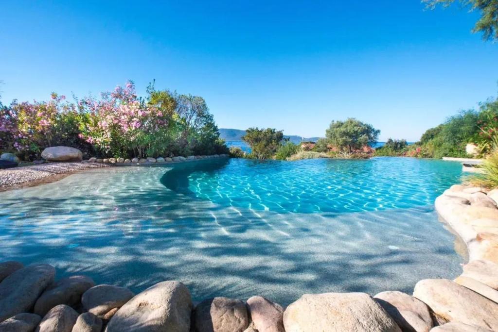 una piscina con rocce in acqua di Charmante maison à Olmeto avec piscine partagée a Olmeto
