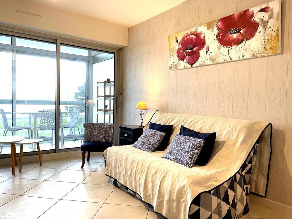 une chambre avec un lit avec des oreillers dessus dans l'établissement Appartement 3* à Perros-Guirec, plage à 50m, garage privé - FR-1-368-73, à Perros-Guirec