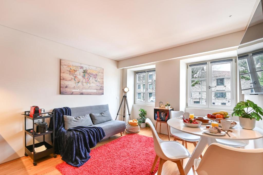 a living room with a couch and a table at Abrigo Muralha By Sé Apartamentos in Braga