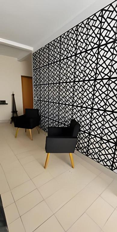 a room with two chairs and a black wall at Rio Quente - Pousada do Charme in Rio Quente
