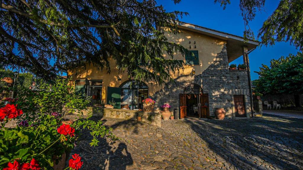 a stone building with flowers in front of it at Casale Colle dell'Asino in Ciampino