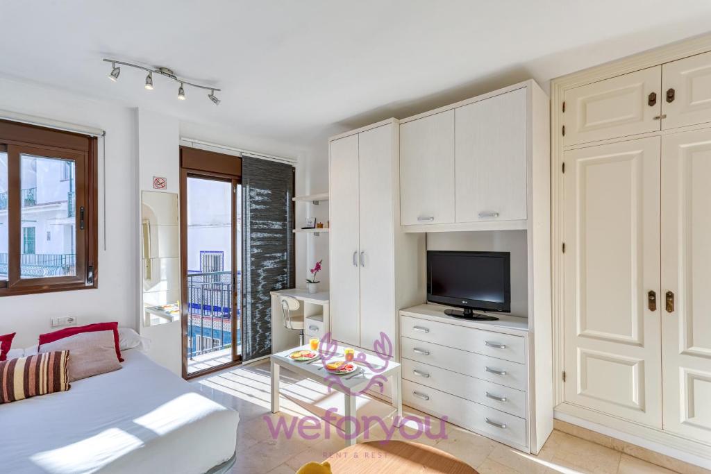 a living room with a bed and a tv at weforyou Old Town Benalmadena in Benalmádena