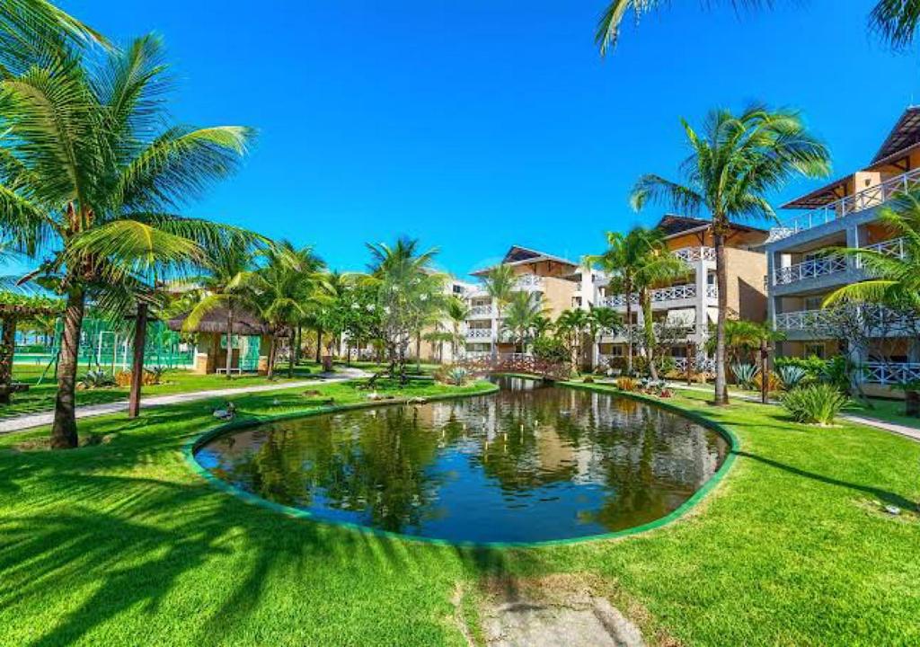 a canal in a resort with palm trees at Apartamento com cobertura no Portamaris Resort in Aquiraz