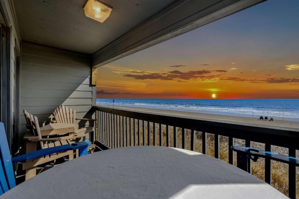 einen Balkon mit Blick auf den Strand bei Sonnenuntergang in der Unterkunft Sea Cabin 118 - Oceanfront in Myrtle Beach