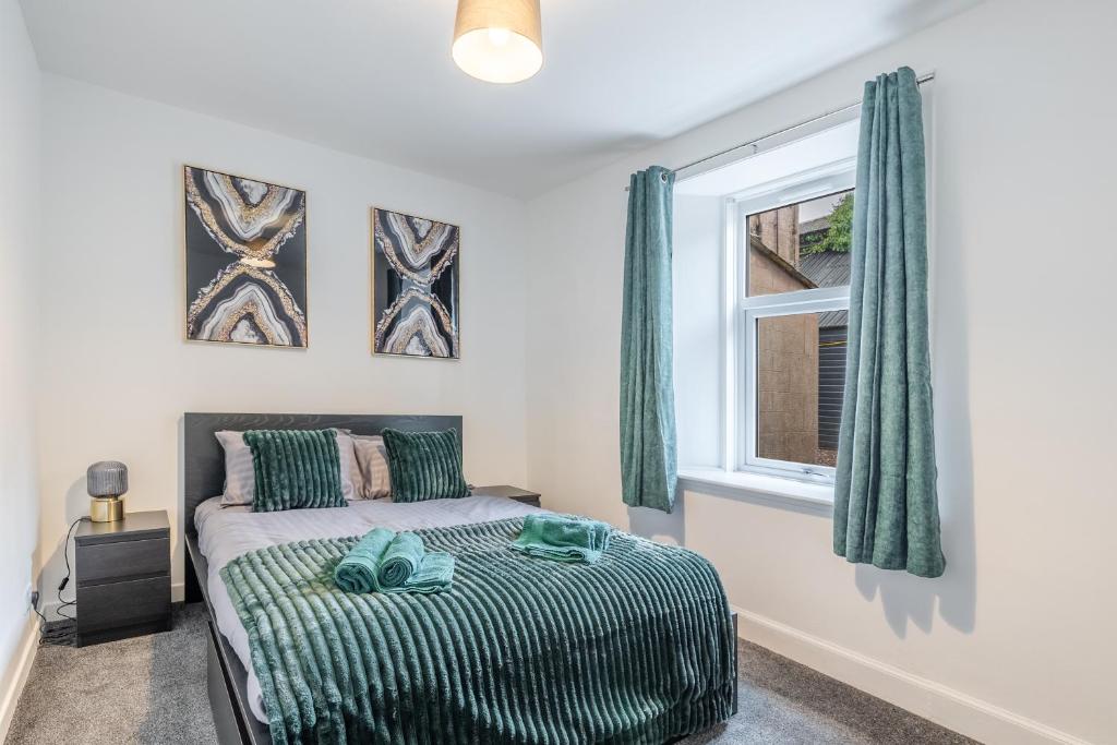 een slaapkamer met een bed en een raam bij Small, Cosy 2BR 1Bathroom Nearby the Town Center in Brechin