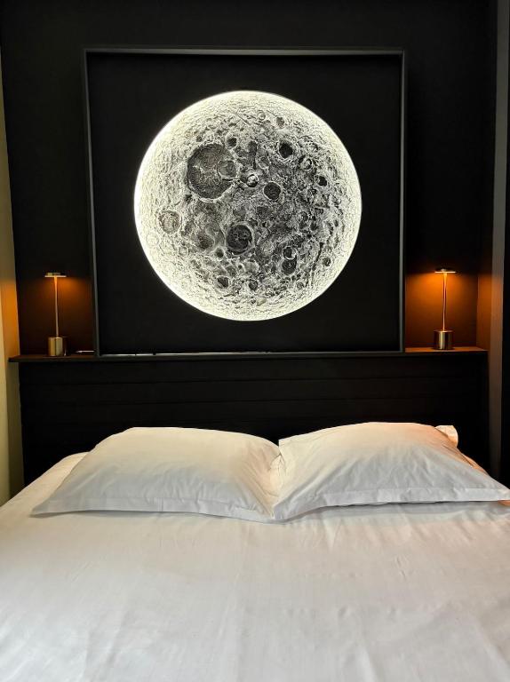 a bed with a painting of the moon at Votre expérience insolite - Clair de lune in Caen