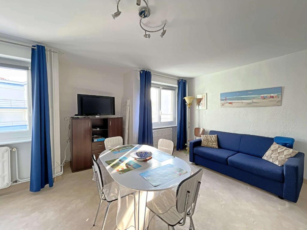un salon avec un canapé bleu et une table dans l'établissement Studio les pieds dans l'eau à Berck-Plage avec parking privatif - FR-1-646-18, à Berck-sur-Mer