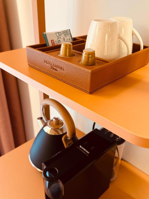 a table with a tea kettle on a table with a tea pot at Hôtel Gabriel in Menton