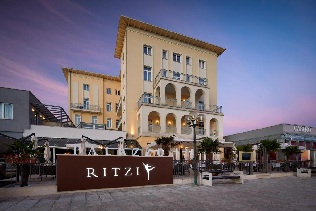 a building with a sign in front of it at BO Hotel Palazzo in Poreč