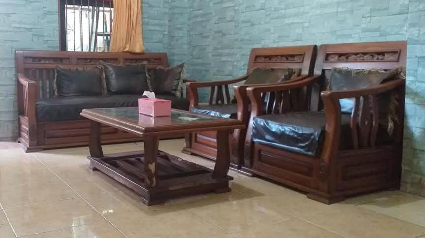a living room with wooden furniture and a table and a couch at Homestay syariah off in Karawang