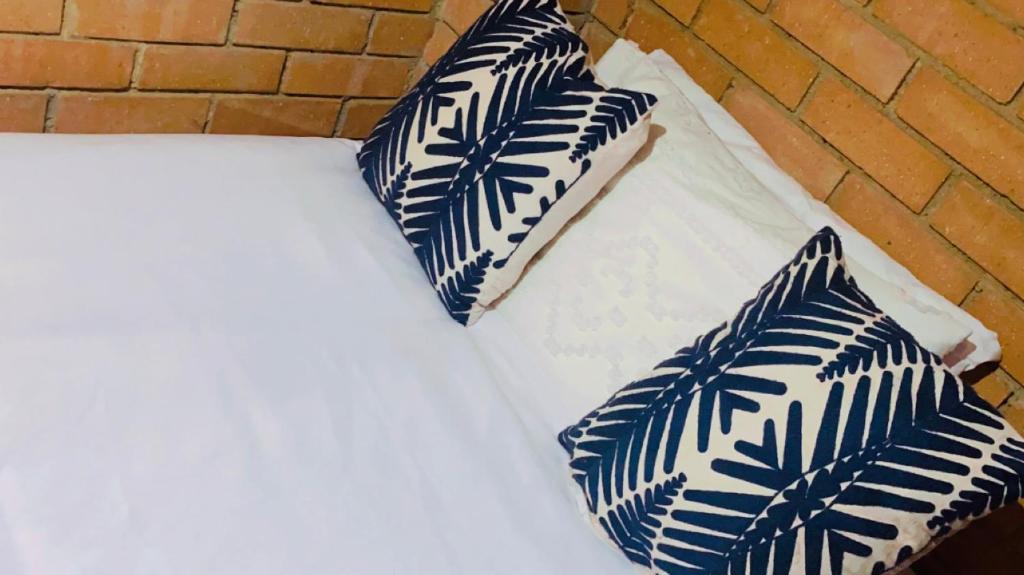 a bed with blue and white pillows on it at Mordern Lil' Love Nest Loft in Midrand in Midrand