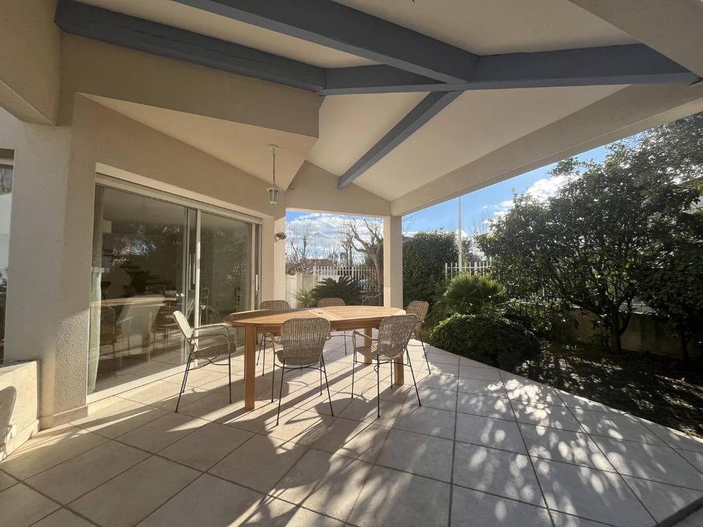 un patio avec une table et des chaises sur un balcon dans l'établissement PORT CAMARGUE - JOLIE VILLA POUR 6 PERSONNES CLIMATISEE AVEC JARDIN ET PARKING, au Grau-du-Roi