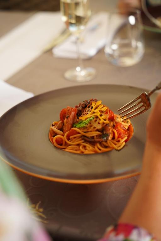 a plate of pasta on a table with a fork at BO Hotel Palazzo in Poreč