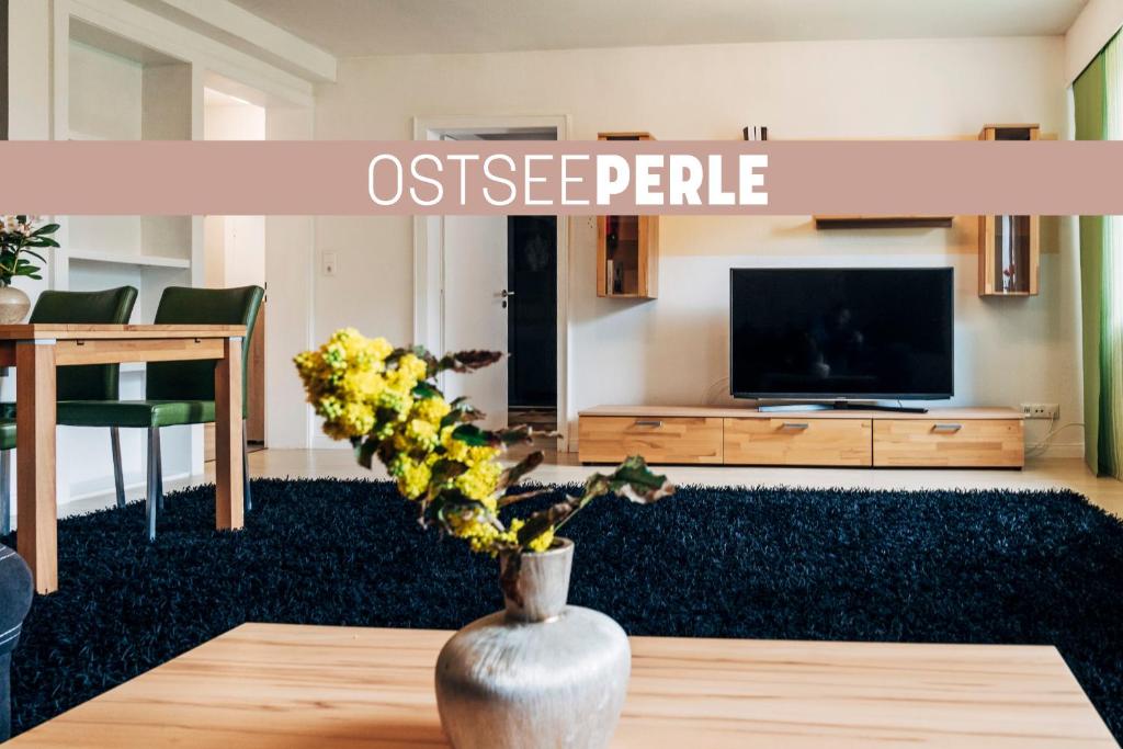 a living room with a vase with flowers on a table at OstseePerle in Solitüde in Flensburg