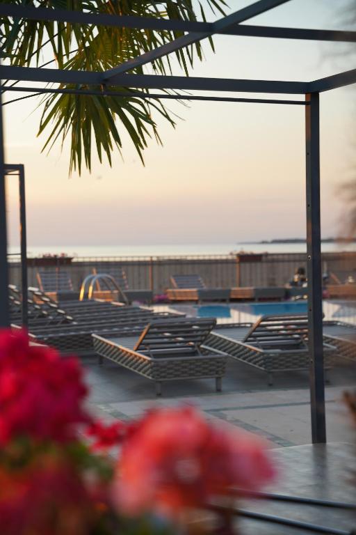 a group of chairs sitting next to a swimming pool at BO Hotel Palazzo in Poreč