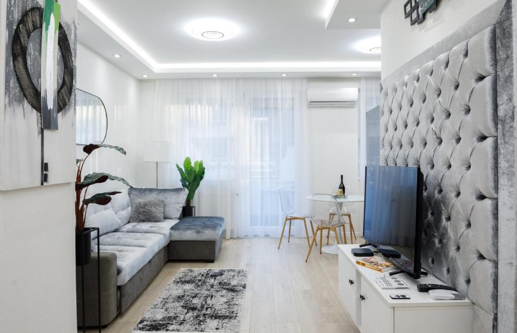 a living room with a couch and a tv at Relax Apartman Free Parking in Debrecen