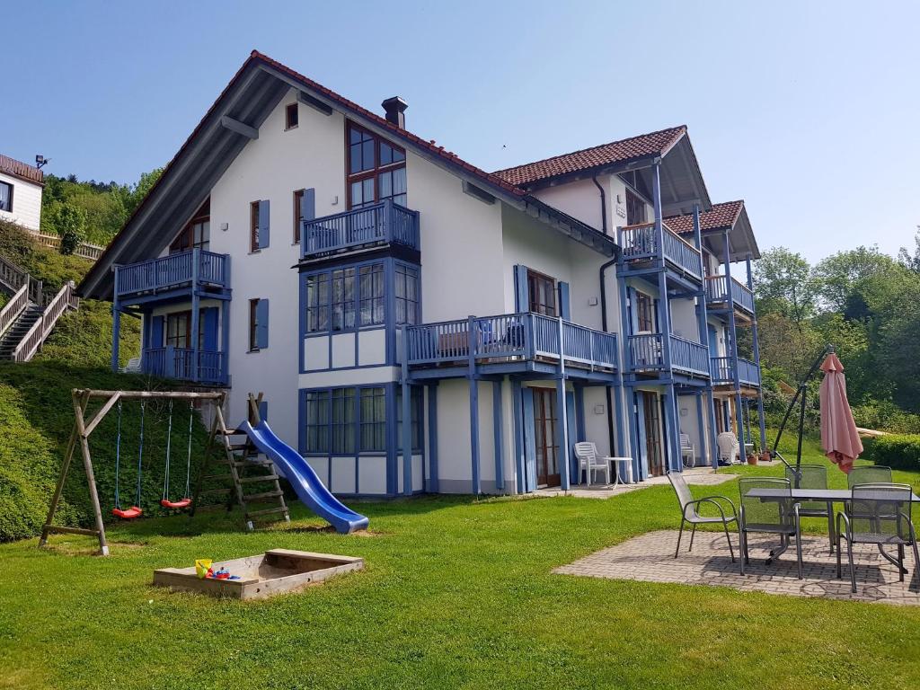 a large house with a playground in the yard at Charmante Wohnung In Langfurth Mit Kleinem Balkon in Schöfweg