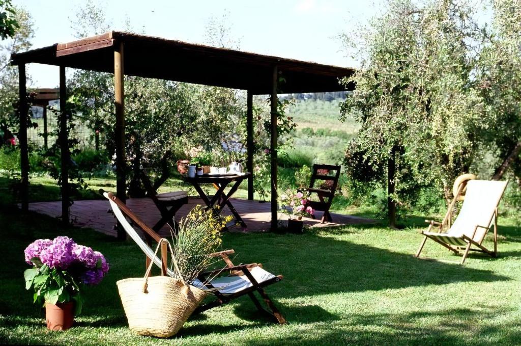 un groupe de chaises et une table dans une cour dans l'établissement Appartamento Rosso, à San Donato in Poggio