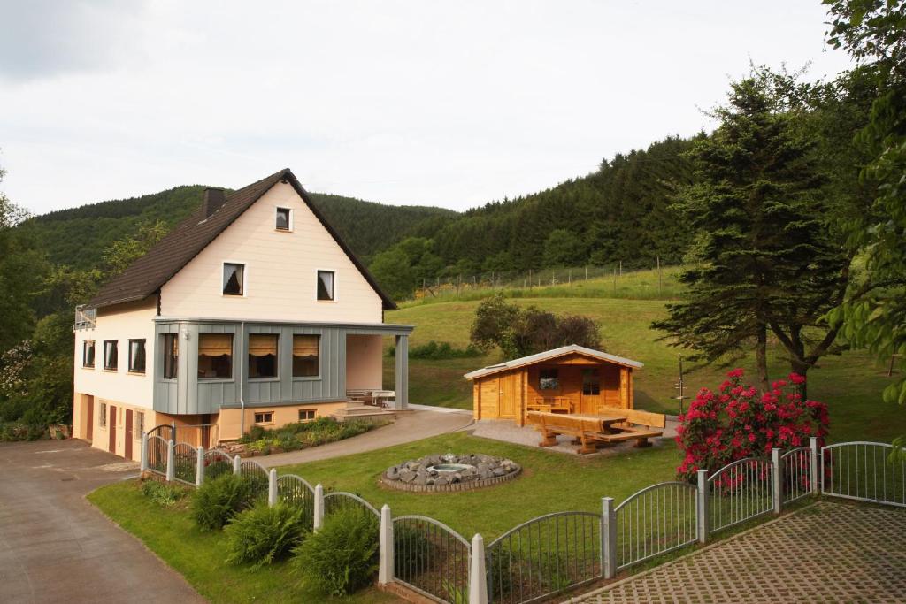 una casa con una hoguera en el patio en Ferienhaus Für 11 Personen Und 1 Kind, en Birresborn