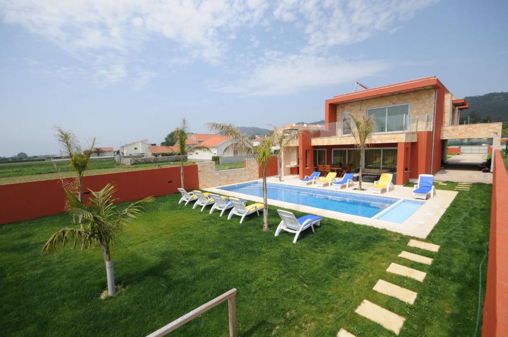 a house with a swimming pool and chairs in the yard at Ferienhaus Für 10 Personen In Esposende in Esposende