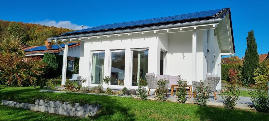 a small white house with a solar roof at Ferienhaus Knoke Ii in Marienmünster