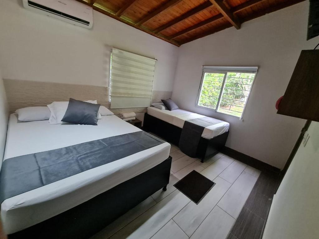 a small bedroom with two beds and a window at Finca Hotel Relax San Jerónimo in San Jerónimo