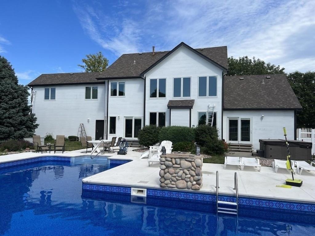 una casa con piscina delante de una casa en Golf Oasis Sleeps 22! Hot tub Firepit Gym Pool, en Omaha
