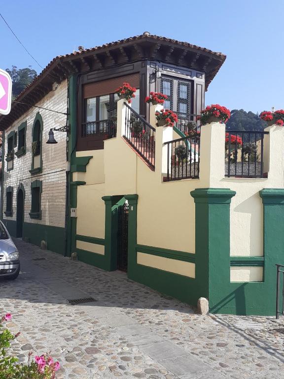 a yellow and green building with flowers on the balconies at Balcon del Alba VUT N1238 in Lastres