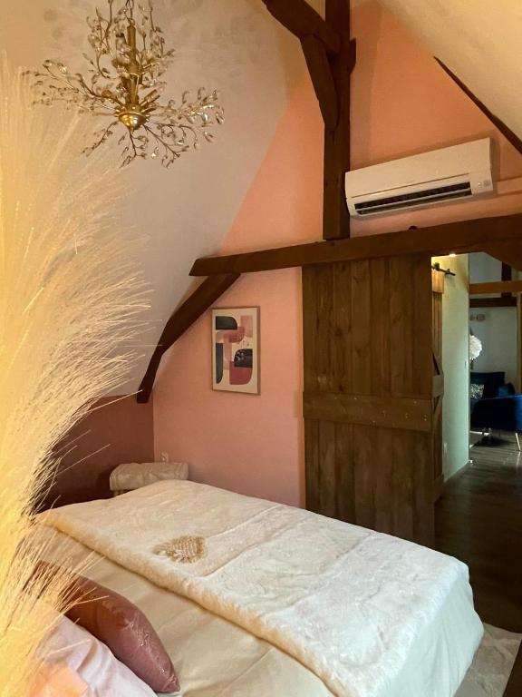 - une chambre avec un lit et un lustre sur le mur dans l'établissement Chambre cosy, à Saint-Amand-les-Eaux