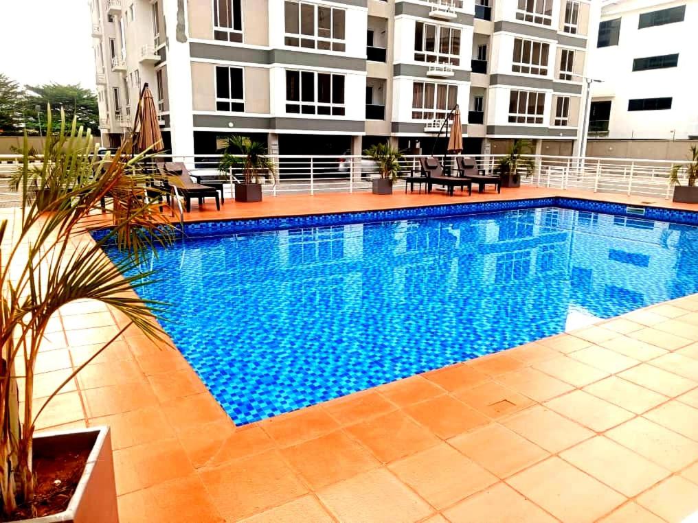 a large swimming pool in front of a building at Cozy Ikoyi Retreat in Lagos