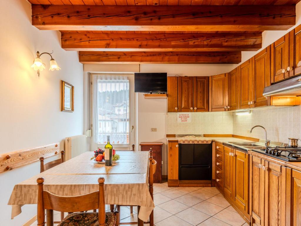 een keuken met houten kasten en een houten tafel bij Apartment Vento Alpino-1 by Interhome in Predaia