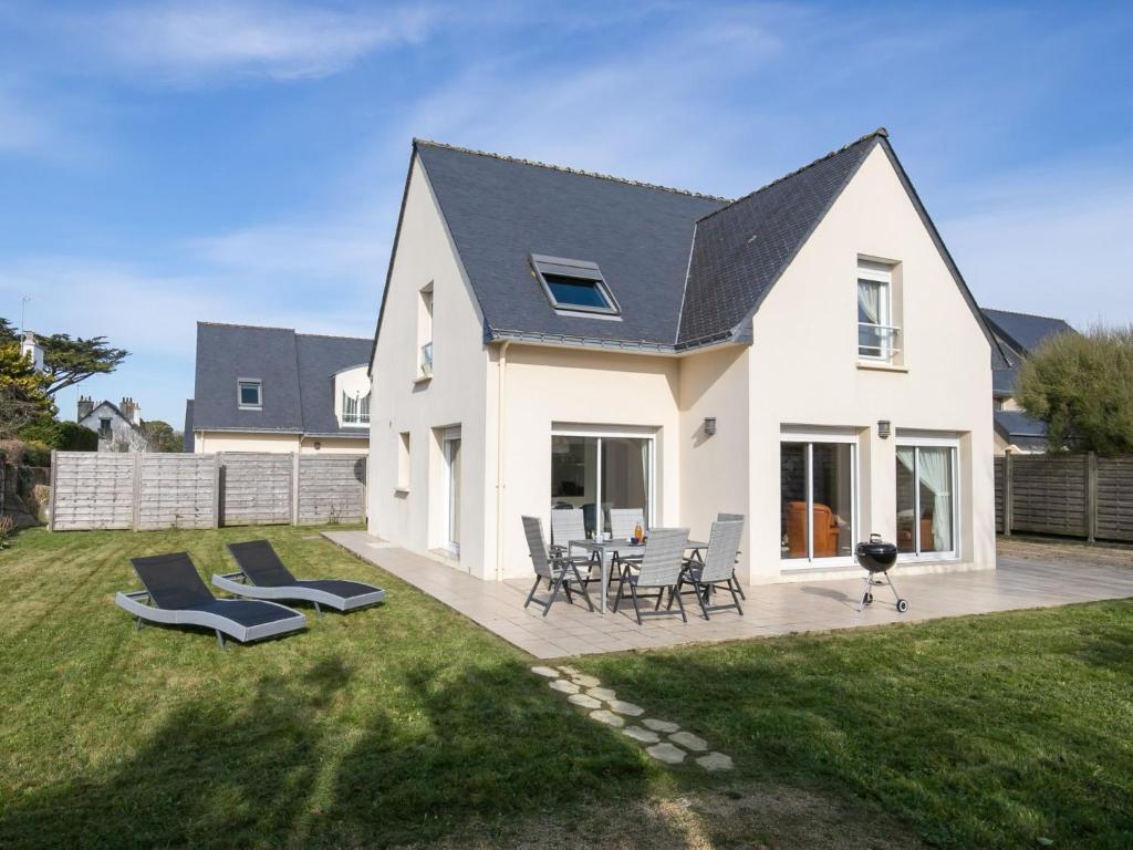 ein weißes Haus mit Stühlen und einer Terrasse in der Unterkunft Holiday Home Villa de la Paix by Interhome in Clohars-Carnoët
