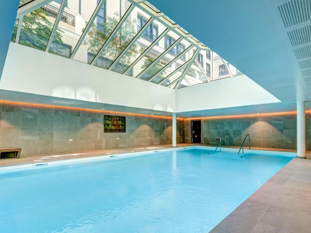 a large swimming pool with a glass ceiling at Zenitude Hôtel-Résidences Val d'Europe in Chessy