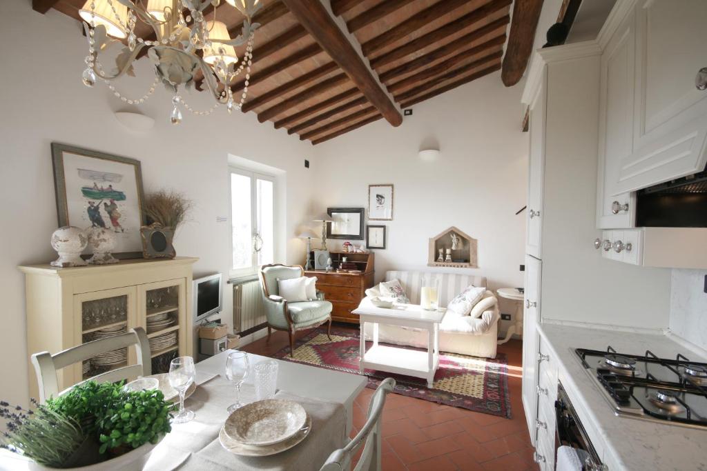 uma cozinha e sala de estar com mesa e cadeiras em Zaffiro Bianco em San Gimignano