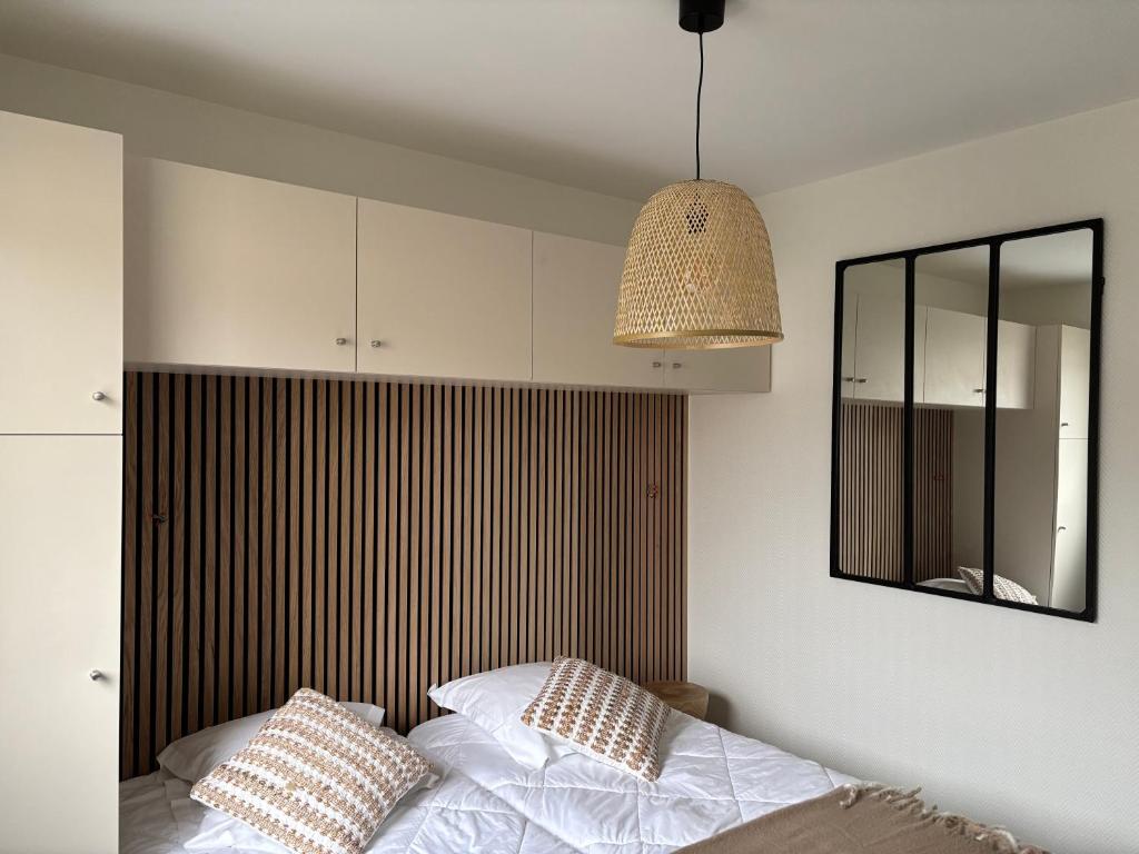 - une chambre avec un lit, un miroir et une lampe dans l'établissement Appart en front de mer pour famille : Molène, à La Bernerie-en-Retz