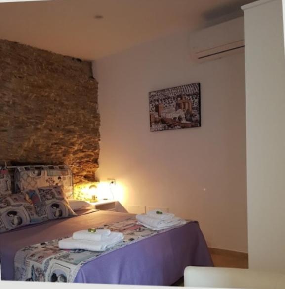 Un dormitorio con una cama con toallas. en Casa Cueva El Arrabal, en Setenil