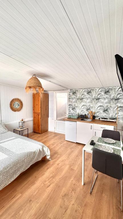 a bedroom with a bed and a table and a kitchen at Sunset View in Arona