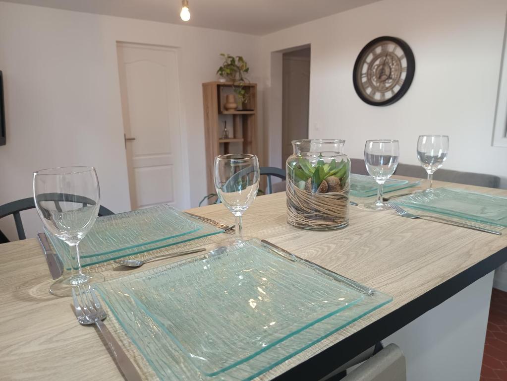 - une table en bois avec des verres et des assiettes dans l'établissement L'Harmonie à 2 pas de la plage - 2 chambres - Terrasse, à Saint-Georges-de-Didonne