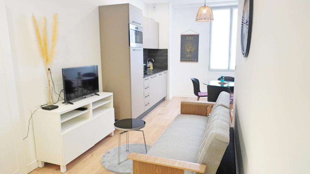 un salon avec un canapé et une télévision dans l'établissement Proche Carlton & Croisette, Appartement 202 - Palmazur Vacances, à Cannes