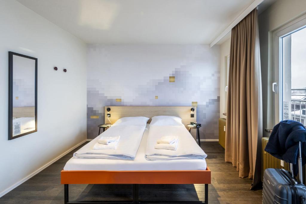 Postel nebo postele na pokoji v ubytování MEININGER Hotel München Zentrum