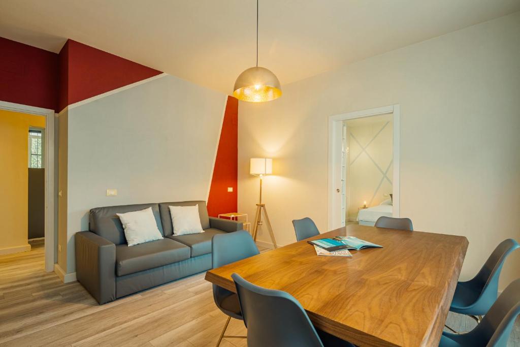 a living room with a table and a couch at Maffi's Apartment - Steps from Pisa Tower in Pisa