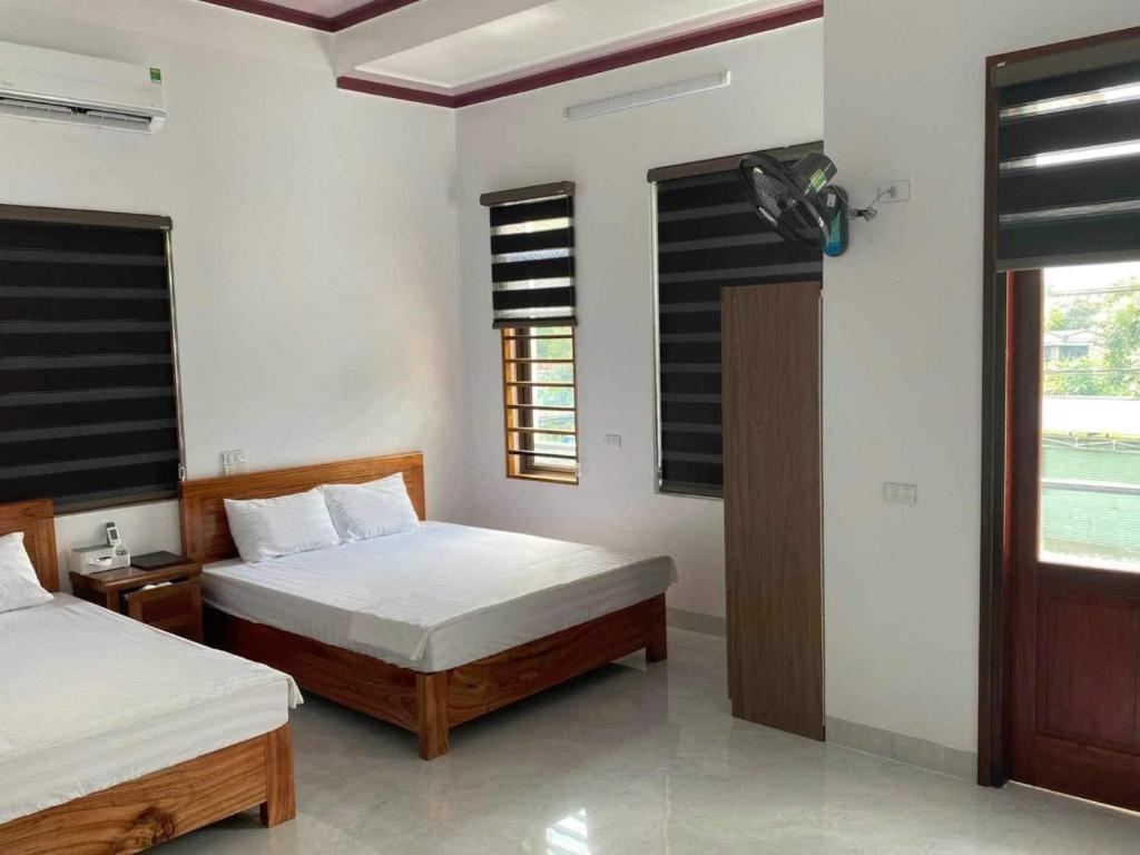 a bedroom with two beds and a window at Thuan Son Hotel in Na Lúng