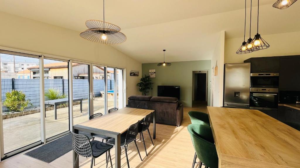 Il dispose d'une cuisine et d'un salon avec une table et des chaises en bois. dans l'établissement La Garenne, piscine et pinède, à Saint-Jean-de-Monts