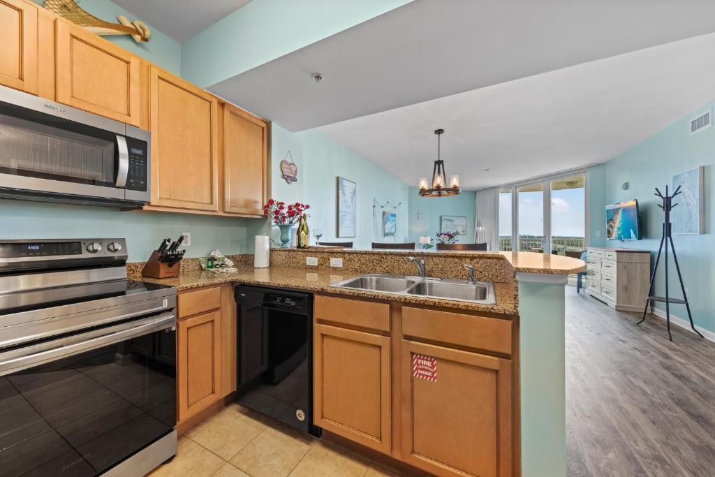 a kitchen with a sink and a stove top oven at 5 Star Resort 11th Fl Stunning Sunrise 2BR 2BA King Suite,Pools ,Shuttle or Walk to Beach in Destin