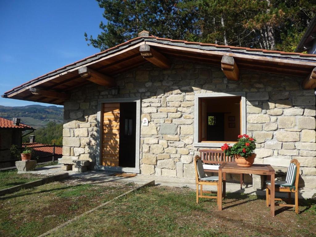 a stone house with a table and chairs in front of it at Magnolia in Pratovecchio
