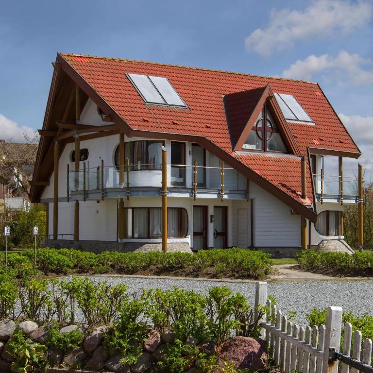 a house with an orange roof at Ferienwohnung Moin Moin In Friedrichskoog Spitze in Friedrichskoog